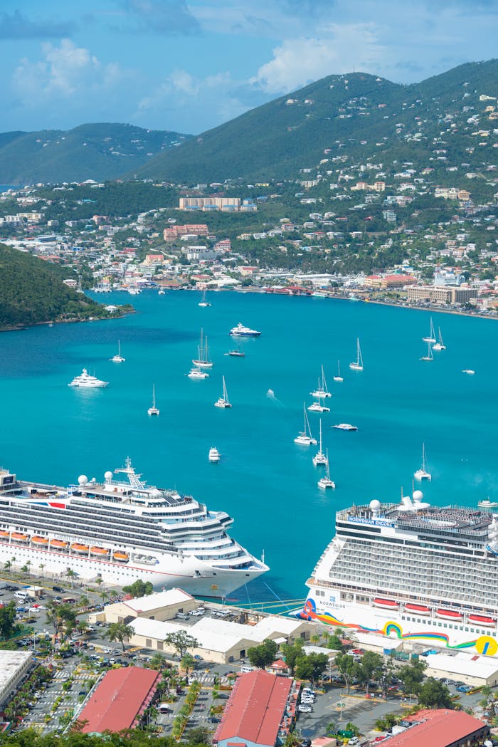 Stunning aerial view of cruise ships docked in a tropical Caribbean harbor surrounded by turquoise waters.